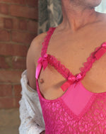 Load image into Gallery viewer, mans chest wearing open cup hot pink ruffle bodysuit. Lingerie for men by Moot Lingerie. 
